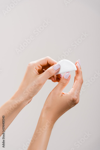 cropped view of woman cleaning fingernails with cotton pad isolated on grey, stock image