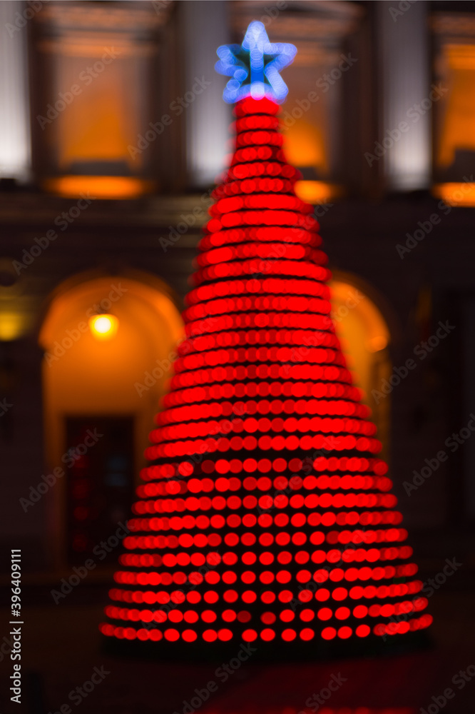 Blurred background with colorful christmas tree illuminated at night.