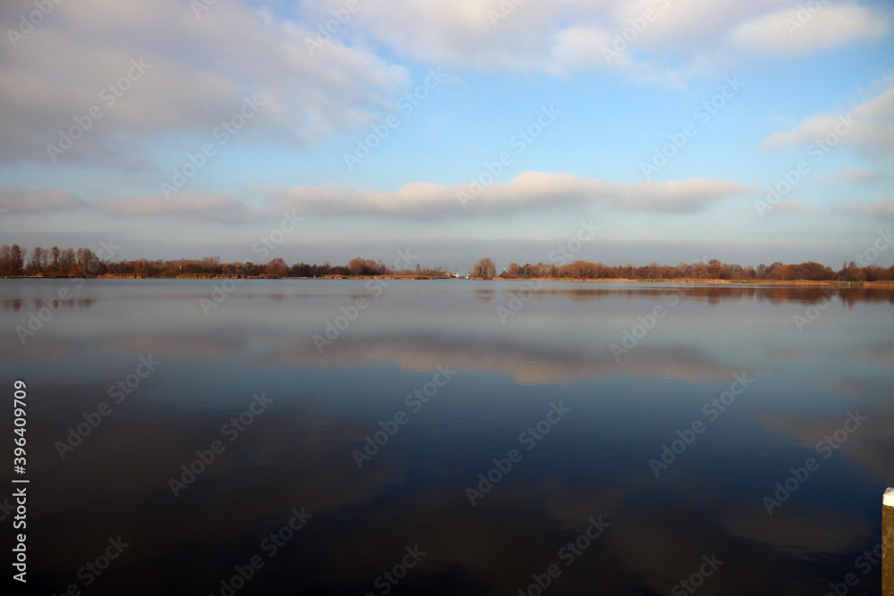 White clouds on a azure blue sky reflection in water surface White clouds on a azure blue sky reflection in water surface