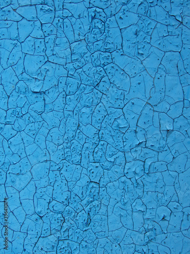 old blue paint on a wooden wall texture. Aged painted cracked boards with blue color peeling paint. Old natural grunge textured wooden texture. Weathered wood.