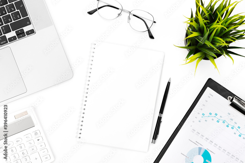 White page of notebook on office desk with laptop, glasses, calculator and pen on white background. Flat lay, top view with copy space for your text. White page of notebook on office desk with laptop, glasses, calculator and pen on white background. Flat lay, top view with copy space for your text.