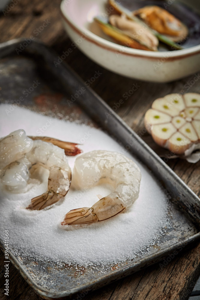 bowl of boiled raw gambas isolated in salt on wood background