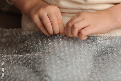 To relieve stress  the child bursts with his fingers bubbles in a plastic wrap.