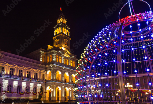 Christmas tree and new year decorations in front of the town hall building, at night, in the city center of Arad, Romania