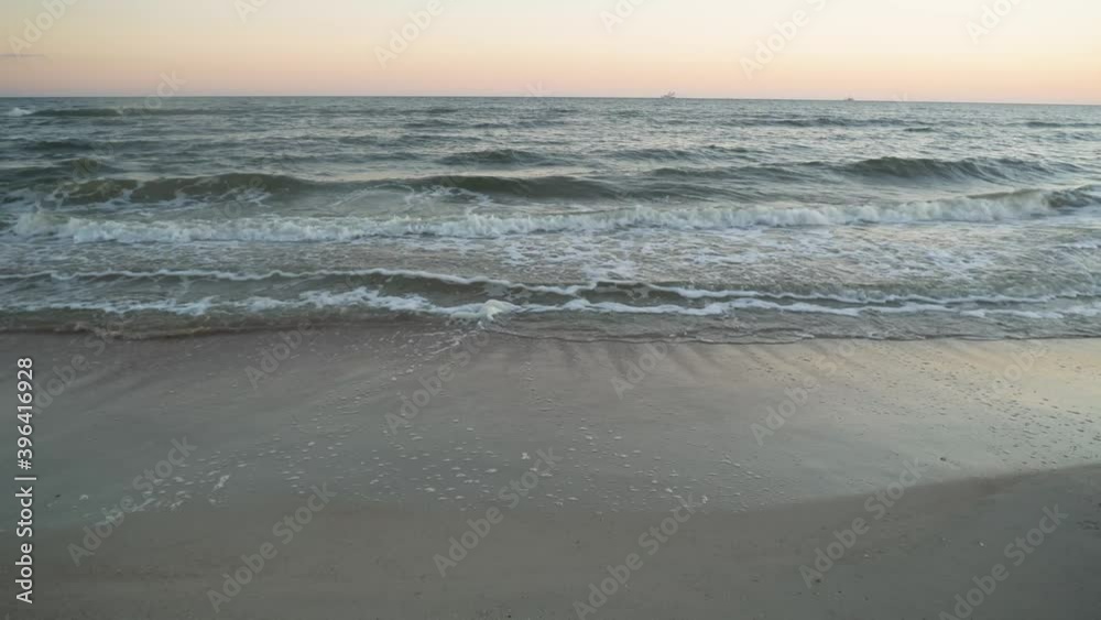 Beautiful ocean waves striking a sand beach at sunset low angle Beautiful ocean waves striking a sand beach at sunset low angle