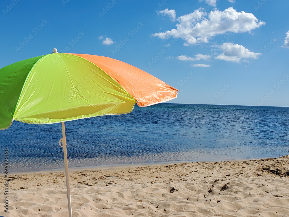 beach umbrella on the sand on a Sunny day, blurred sea in the background.