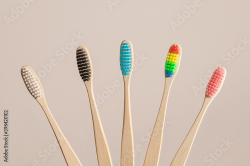 Multicolored bamboo toothbrushes on beige background