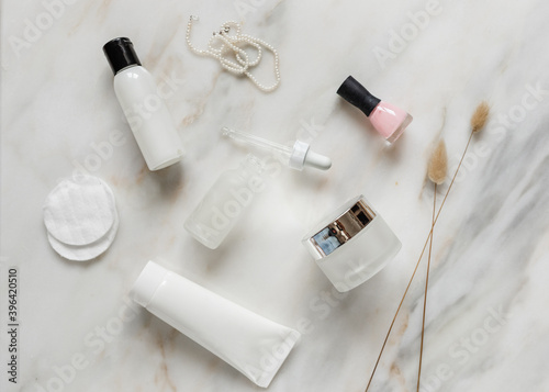 flat lay of beauty products on marble background, cream, bottle, dropper bottle, nail polish, white, pink, mock up for a banner, beauty blog 