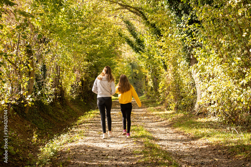 Deux jeunes filles marchant sur un petit chemin lumineux en automne photo