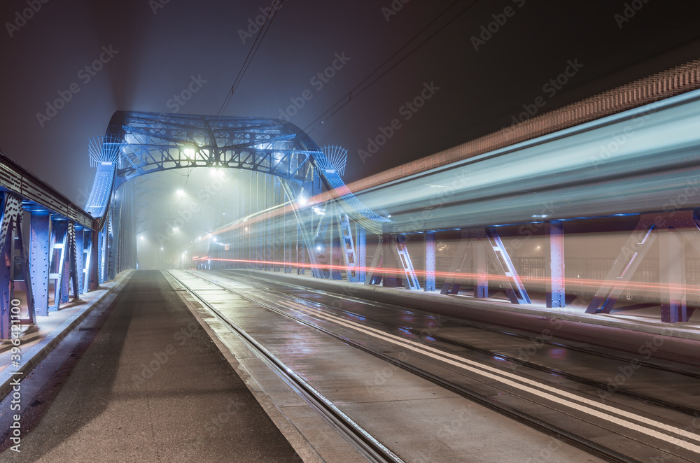 Krakow Poland, tram light trails on Pilsudski bridge over Vistula river in the night