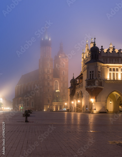 Main market square  Cloth Hall and St Mary s church in the misty night  Krakow  Poland