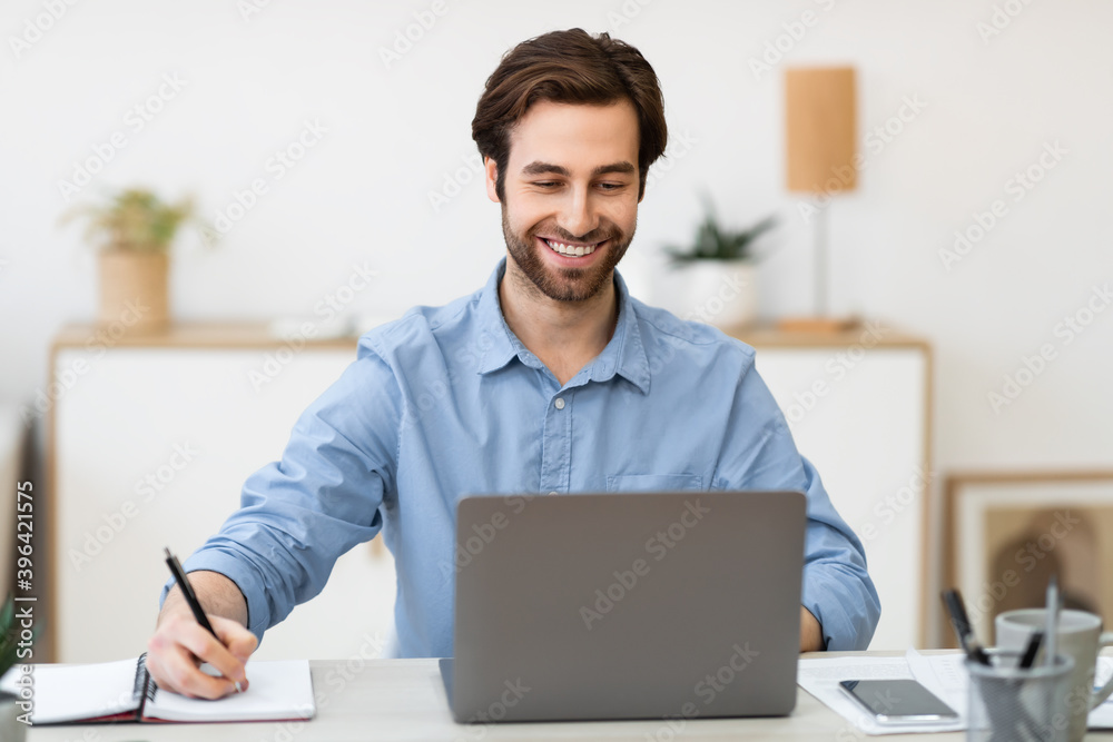 Cheerful Businessman Taking Notes Working At Workplace In Office Cheerful Businessman Taking Notes Working At Workplace In Office