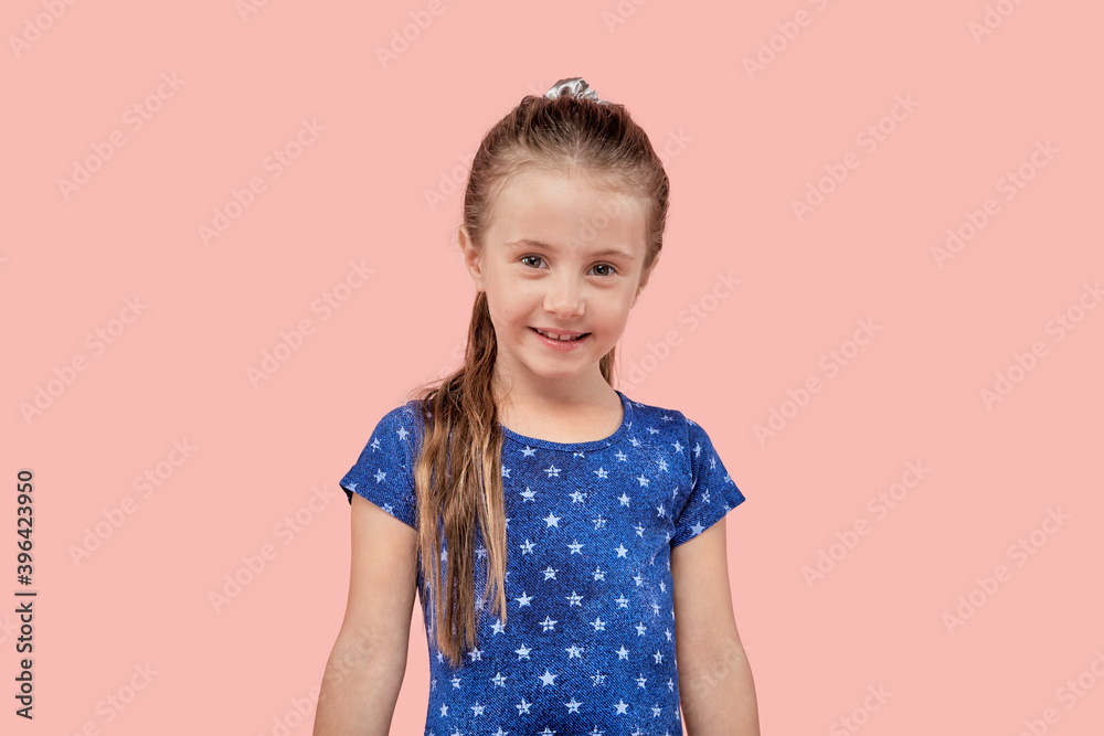 Portrait of a cute smiling beautiful girl looking at the camera on a pink isolated background. Blue dress with a small star. Portrait of a cute smiling beautiful girl looking at the camera on a pink isolated background. Blue dress with a small star.