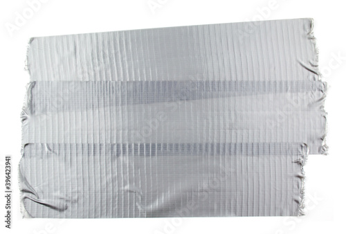 Torn pieces of silver grey adhesive duct tape isolated on white background.
