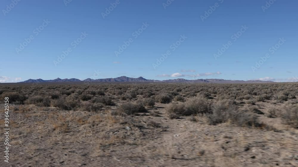 Slow motion bumpy ride over a dirt road running through the desert with mountains in the distance. Slow motion bumpy ride over a dirt road running through the desert with mountains in the distance.