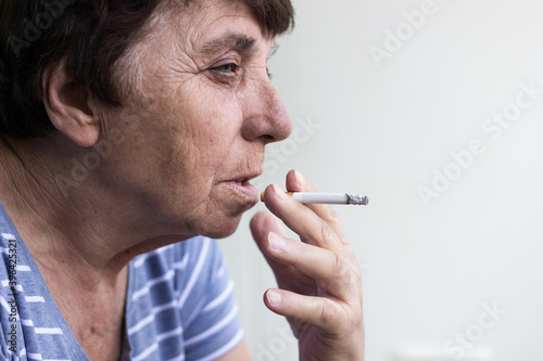 Foto Senior woman smoking a cigarette