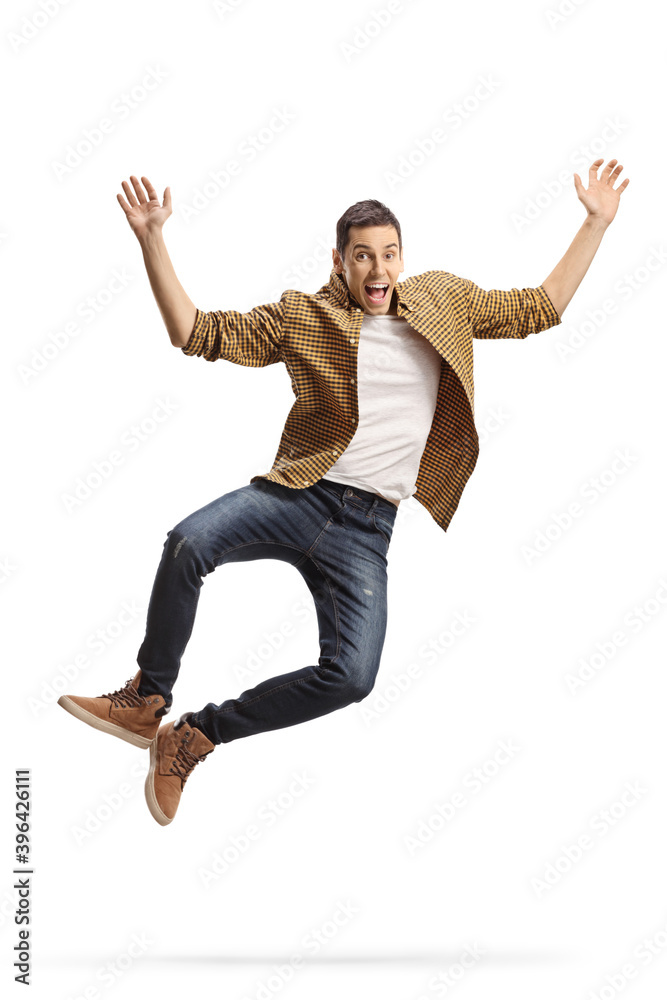 Excited young man in shirt and jeans jumping Excited young man in shirt and jeans jumping