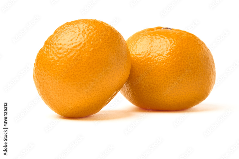 Two orange tangerines lined up on top of each other on an isolated background. Two orange tangerines lined up on top of each other on an isolated background.