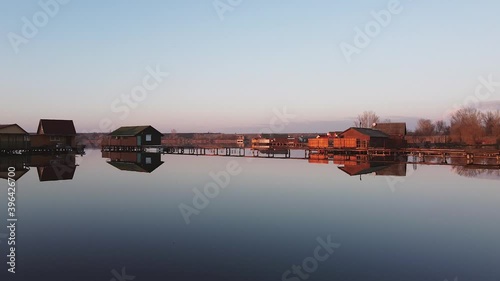 Fly over lake and fishing cabins