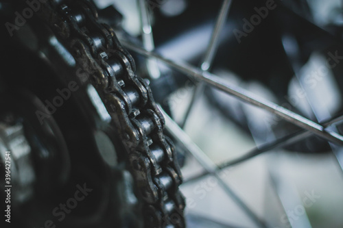 Detail of a motorcycle chain mounted on a rear hub. Dark grunge photo of a bike chain.