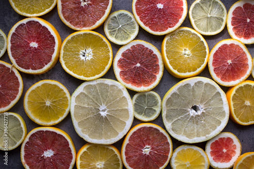 Colorful background made of red orange, lime, grapefruit and lemon slices. Beautiful colors of fruit texture. Citrus close up photo. Healthy eating concept. 