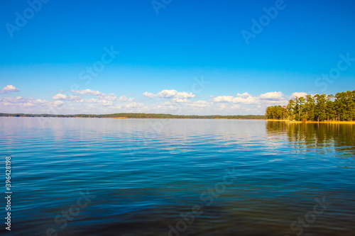 A beautiful lake scene with blue sky and clouds reflecting