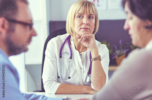 Attentive senior doctor listenint to patient in her office