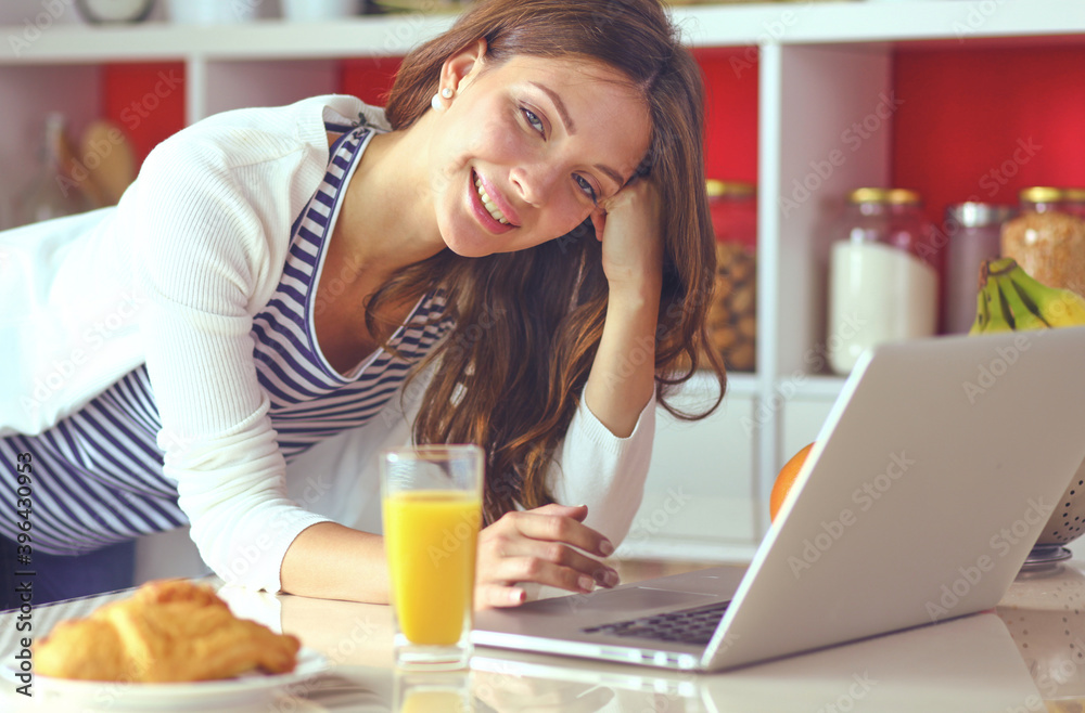 Young woman sitting near desk in the kitchen Young woman sitting near desk in the kitchen