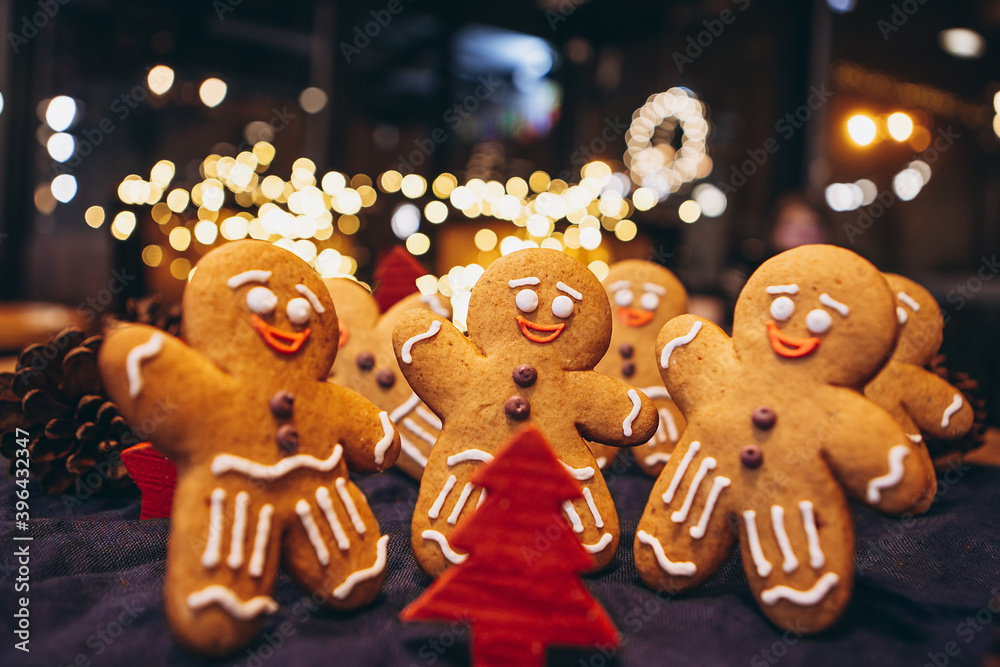 Many Christmas cookies in the form of gingerbread men depicting people celebrating the New Year in the forest near the Christmas tree