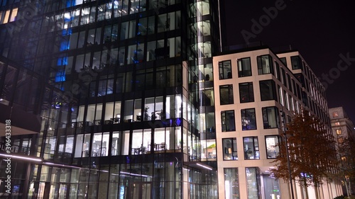 Pattern of office buildings windows illuminated at night. Lighting with Glass architecture facade design with reflection in urban city. © Grand Warszawski