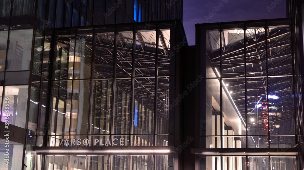 Fototapeta premium Pattern of office buildings windows illuminated at night. Lighting with Glass architecture facade design with reflection in urban city.