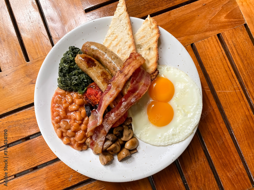 Breakfast with Cumberland sausages, fried eggs sunny side up, sautéed