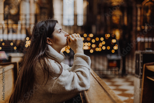 Christian woman prays in church. Hands crossed on wooden table. Christian Background