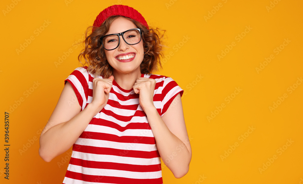 Excited stylish female smiles and rejoices on colorful yellow background Excited stylish female smiles and rejoices on colorful yellow background