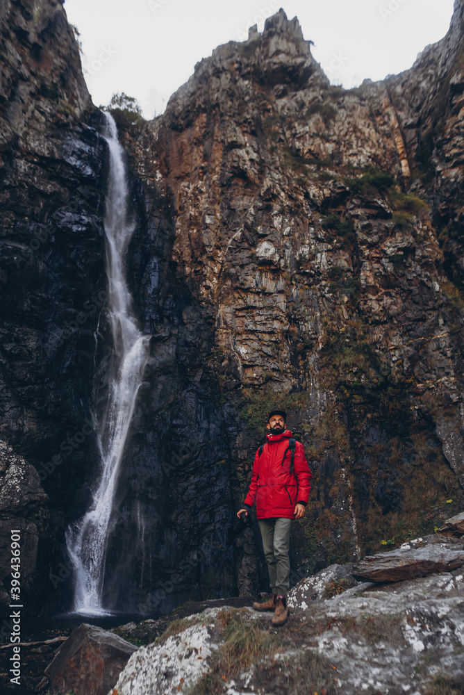 01.06.2019 Stepancminda, Georgia: Bearded Travel photographer man taking nature photo or video of mountain landscape in Georgia
