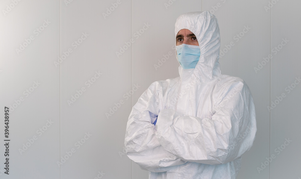 A health worker in a protective suit crosses his arms. Coronavirus pandemic. A health worker in a protective suit crosses his arms. Coronavirus pandemic.