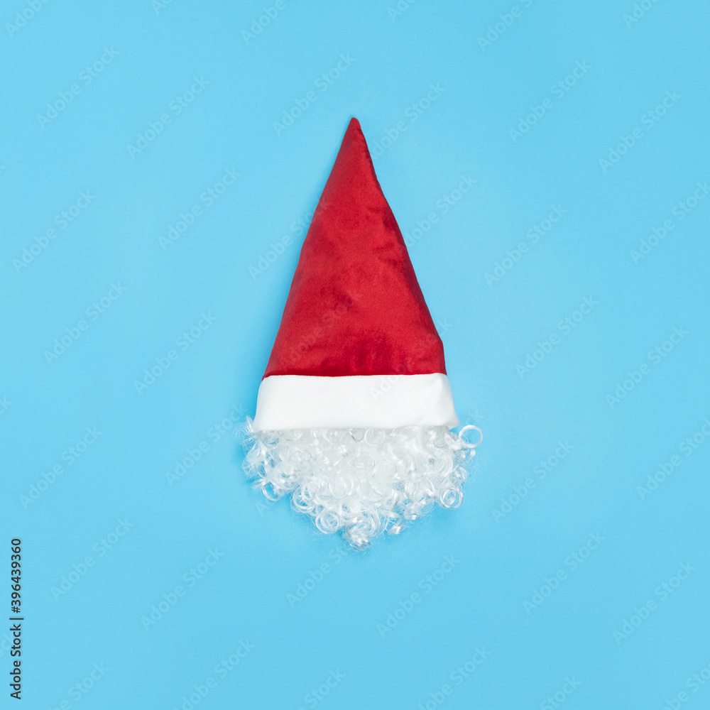 Head of Santa Claus in hat on blue background. Minimal Christmas concept. White beard Head of Santa Claus in hat on blue background. Minimal Christmas concept. White beard