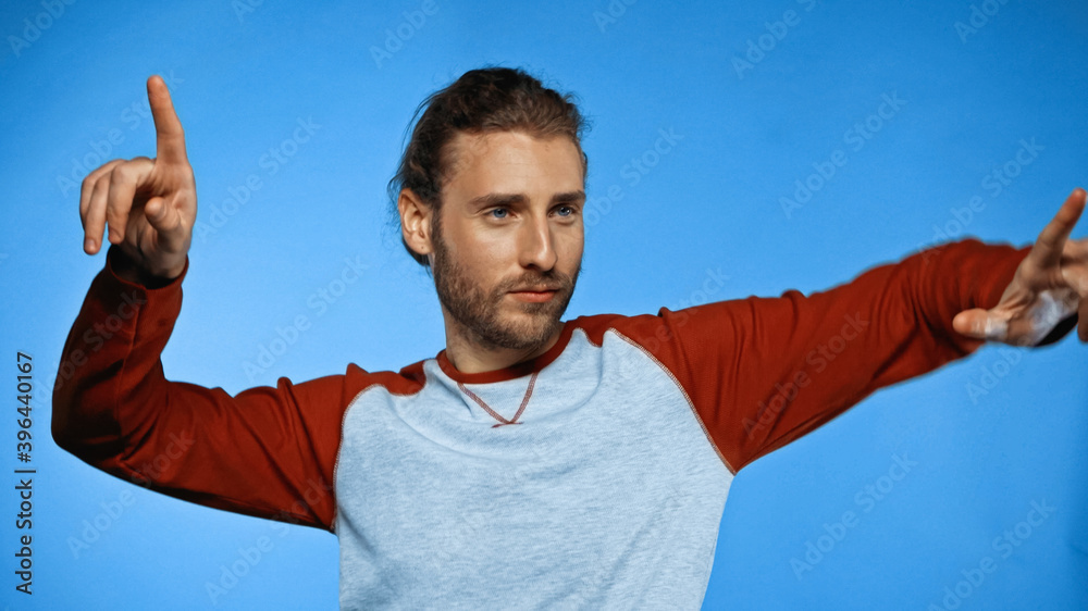 bearded young man pointing with fingers on blue bearded young man pointing with fingers on blue