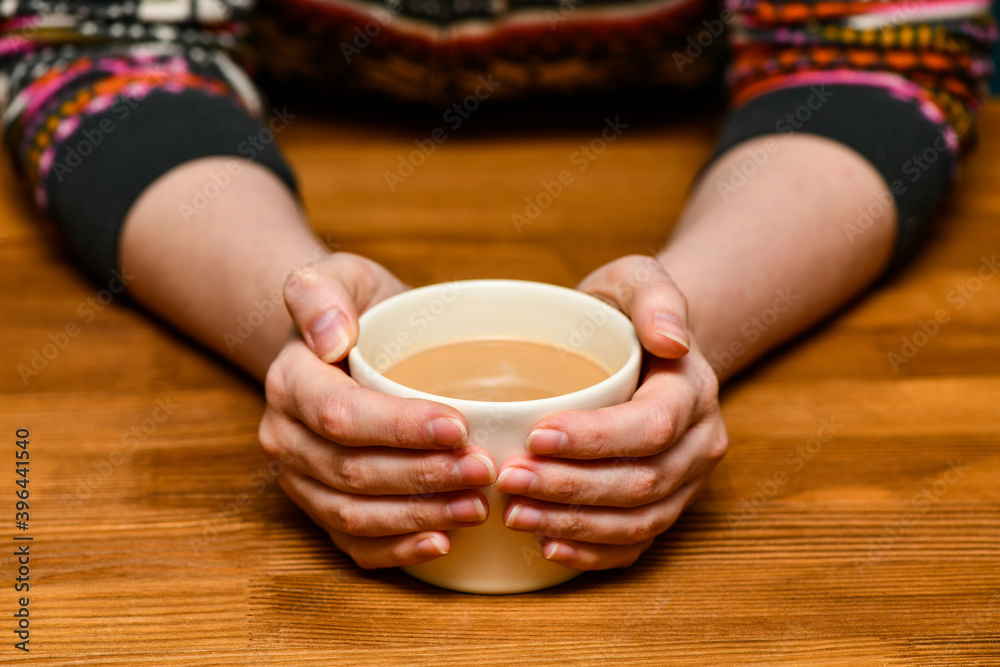 Young woman holding hot cocoa or coffee cup. Autumn or winter moody weekend, New Year, and Christmas background. Lazy day, quarantine, stay home, cozy scene, hygge concept. Young woman holding hot cocoa or coffee cup. Autumn or winter moody weekend, New Year, and Christmas background. Lazy day, quarantine, stay home, cozy scene, hygge concept.