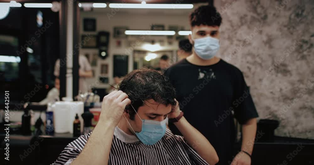 Barber and the client put on virus protection masks. Men's haircut in quarantine. Barber and the client put on virus protection masks. Men's haircut in quarantine.
