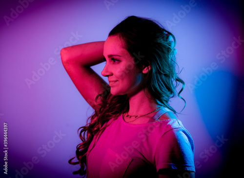 Young woman in her mid-20s - RGB colored portait shot stylish illuminated - home shooting