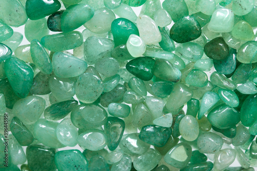 Small stones of green aventurine. Ornamental stone in the form of fine-grained pebbles. Healing stone in folk medicine and astrology photo