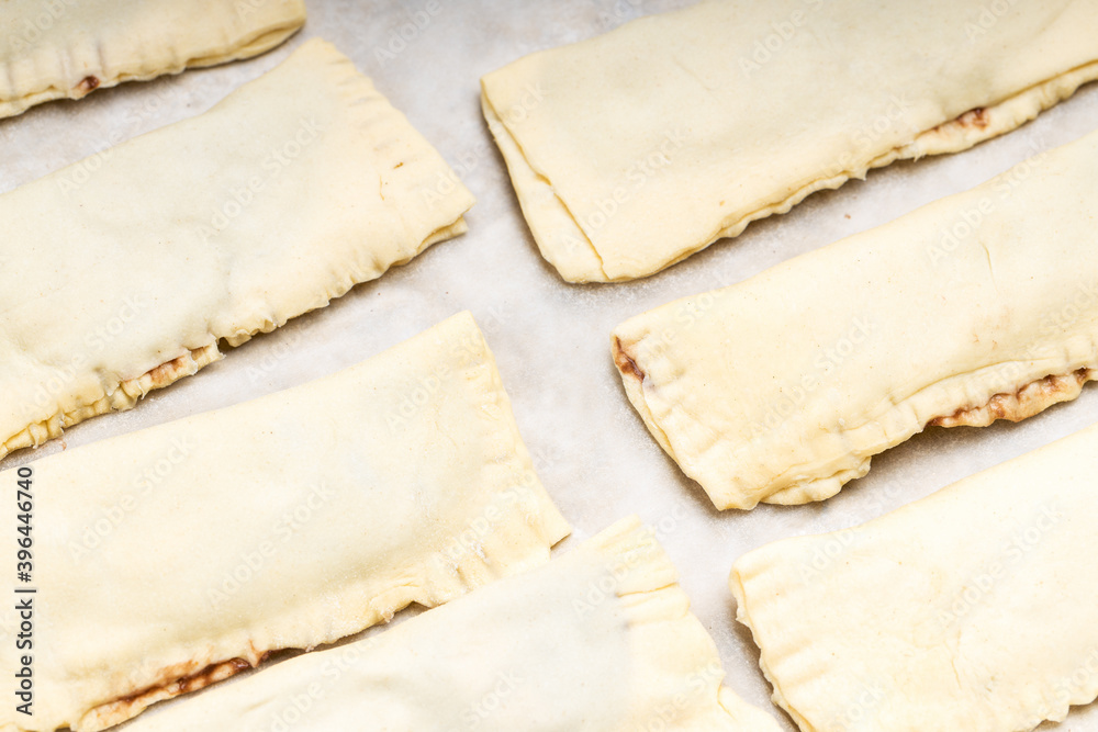 uncooked sweet pastry bun at a cooking tray. homemade cooking concept uncooked sweet pastry bun at a cooking tray. homemade cooking concept