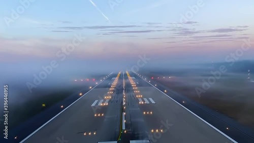 Incredible cockpit pov of airplane landing on airport runway with fog at sunset
