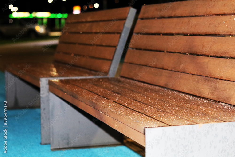 Wooden bench outside in the dark covered with frost Wooden bench outside in the dark covered with frost