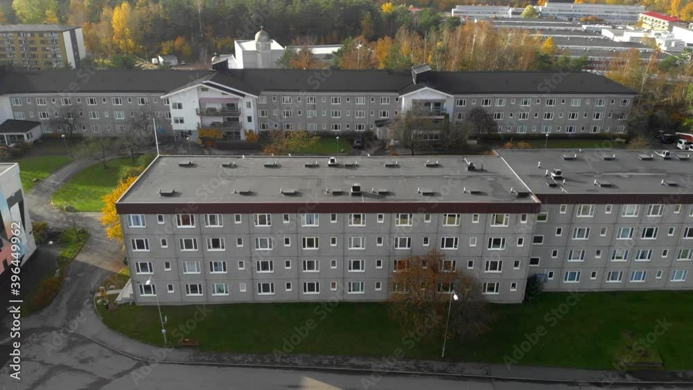 Aerial view of a flat residential building complex in a city neighborhood with autumn colored trees around, crane wide shot Aerial view of a flat residential building complex in a city neighborhood with autumn colored trees around, crane wide shot