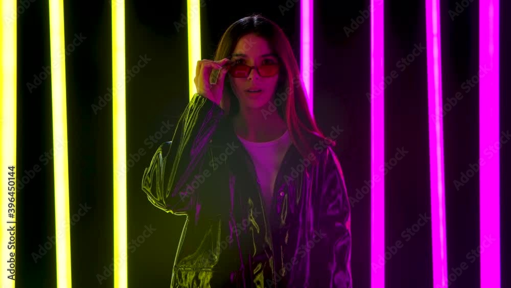 Portrait of a pretty young beautiful woman in stylish sunglasses looking at the camera with a wow enthusiastic expression. Slow motion. Portrait of a pretty young beautiful woman in stylish sunglasses looking at the camera with a wow enthusiastic expression. Slow motion.