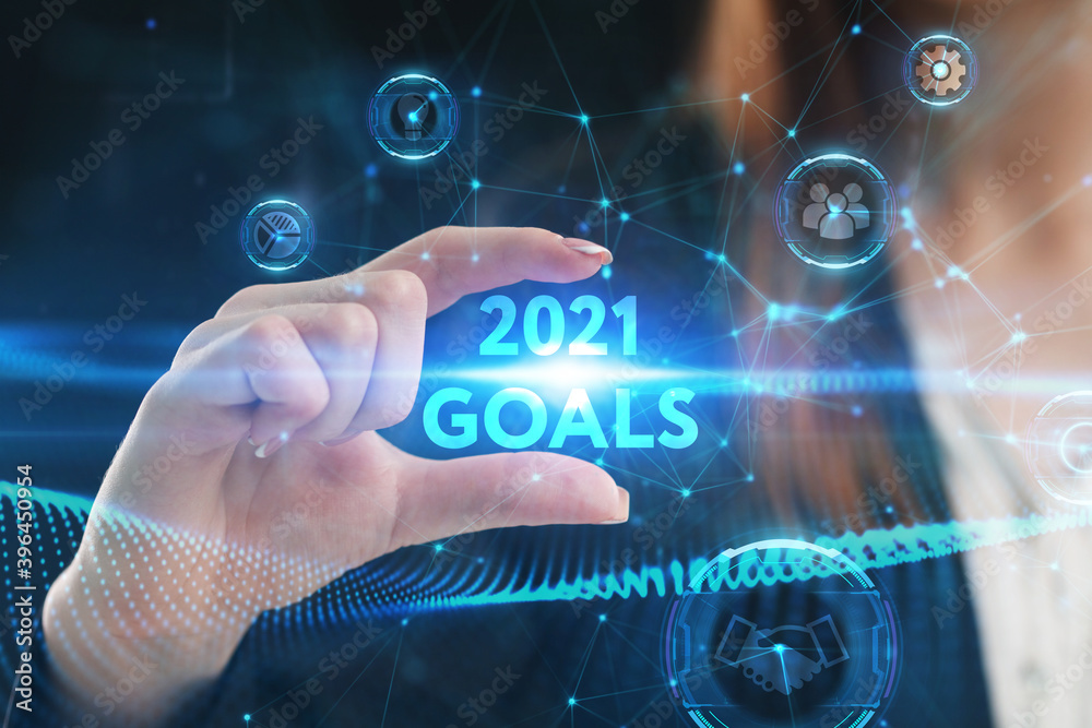 Business, Technology, Internet and network concept. Young businessman working on a virtual screen of the future and sees the inscription: 2021 goals Business, Technology, Internet and network concept. Young businessman working on a virtual screen of the future and sees the inscription: 2021 goals