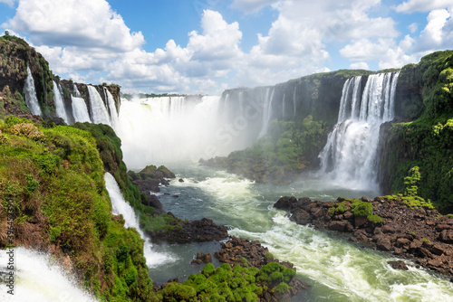 Natural landscape of Cataratas do Igua  u  also know as Iguazu Waterfalls in the border of Brazil and Argentina. Devil s Throat water fall visible with huge flow of water from Paran   River. 