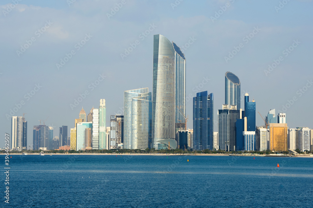 Skyline of Abu Dhabi, United Arab Emirates with multiple skyscrapers in the Corniche. Multiple modern buildings with mirrored glass in the Middle East
